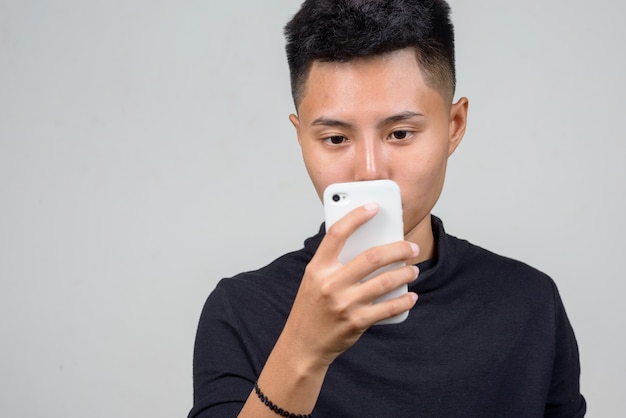 Studio shot di giovani asiatici donna lesbica con i capelli corti su sfondo bianco