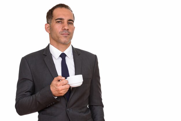 Studio shot di maturo bello uomo d'affari persiano in tuta isolata su sfondo bianco