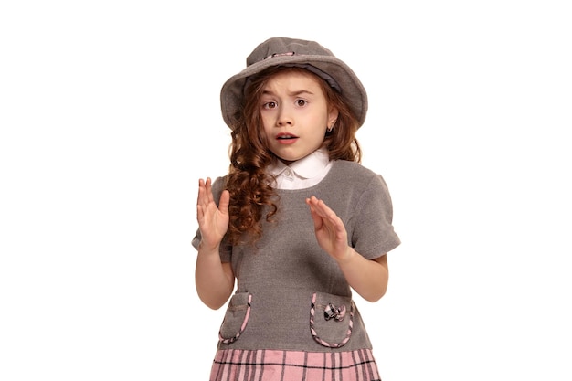 Studio shot di un adorabile ragazzino con lunghi capelli ricci in posa isolato su sfondo bianco