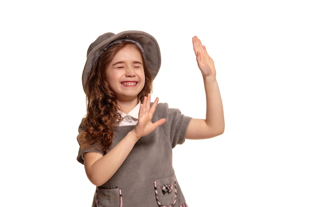 Studio shot di un adorabile ragazzino con lunghi capelli ricci in posa isolato su sfondo bianco