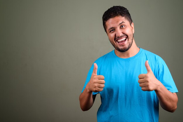 Studio shot di uomo barbuto che indossa la maglietta blu contro colorato