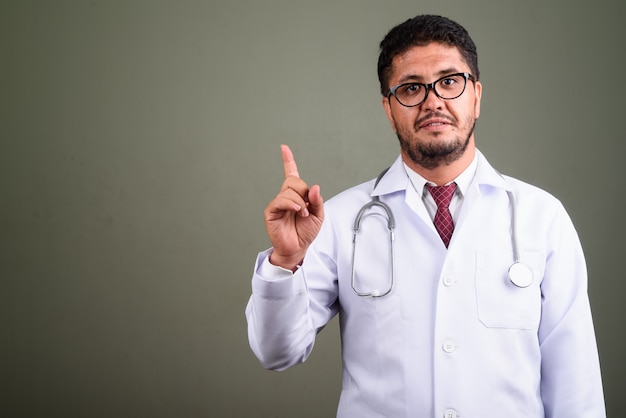 Studio shot di uomo barbuto medico contro colorato