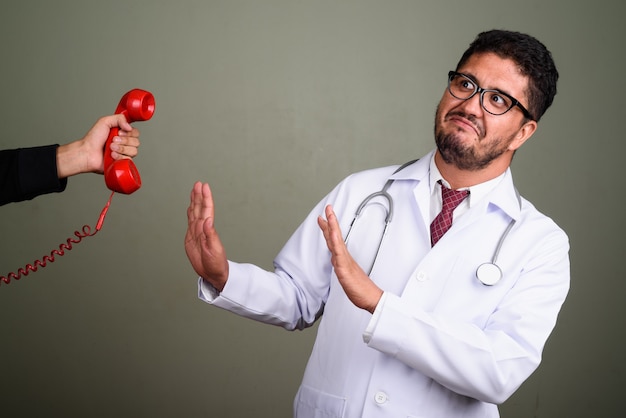 Studio shot di uomo barbuto medico contro colorato