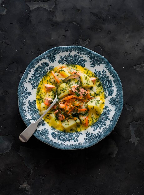 Stufato cremoso con salmone e patate su uno sfondo scuro vista dall'alto