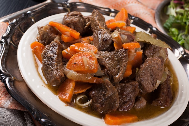 Stufato di manzo delizioso del bourguignon sul piatto bianco