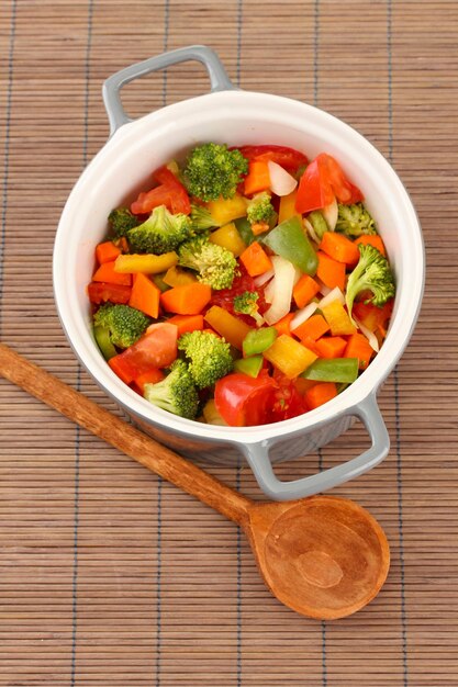 Stufato di verdure in pentola grigia su sfondo stuoia di bambù