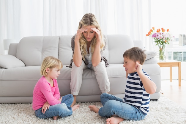 Stufo della madre che ascolta i suoi bambini piccoli a combattere