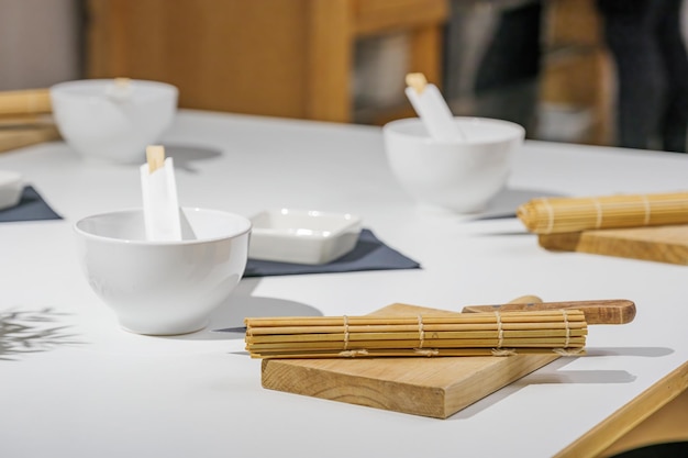 Stuoia di sushi di bambù e coltello su un tagliere. Un set di utensili per fare il sushi in una master class