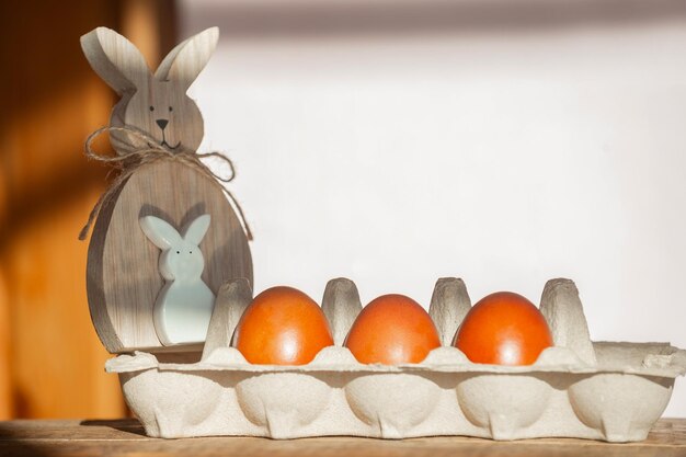 su fondo in legno, una scatola di cartone con uova di Pasqua rosse dipinte con colori naturali