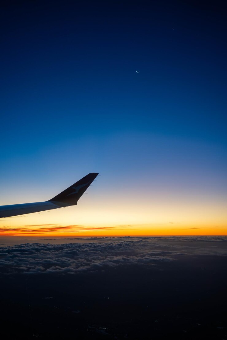 Foto su un aereo che guarda sopra l'ala al tramonto