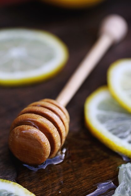 Su uno sfondo di struttura in legno un limone e miele su un cucchiaio