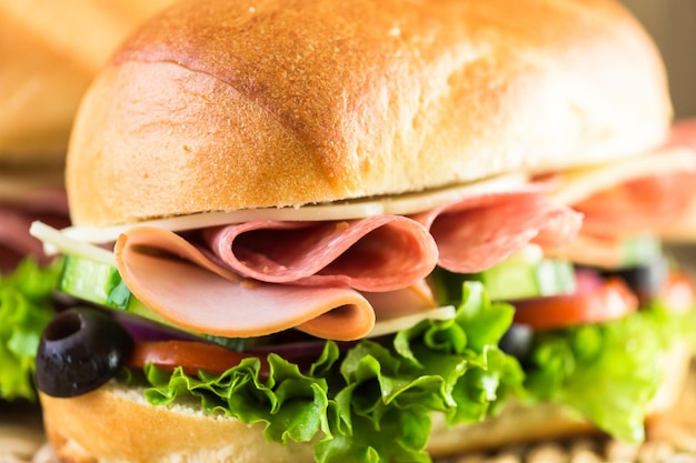 Sub sandwich con verdure fresche, pranzo a base di carne e formaggio su hoagie roll.