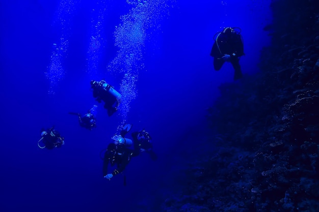 subacquei sott'acqua in profondità sullo sfondo blu del mare