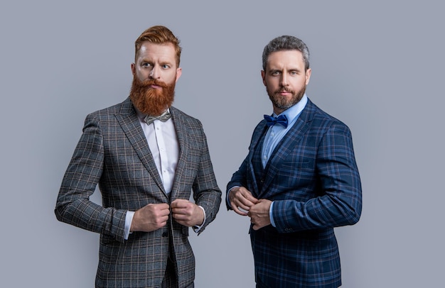 Successo di due uomini in tuxedo menswear colpo in studio di uomini che indossano uomini eleganti da uomo