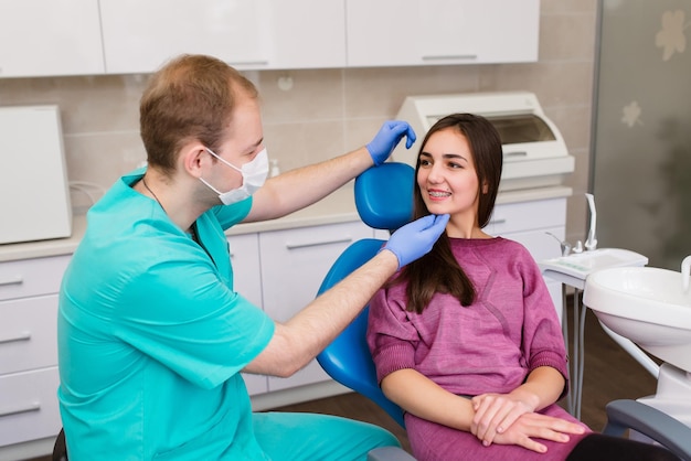 Successo felice dentista caucasico ortodonte che cura la guarigione dei pazienti cavità della bocca riempimento della carie dentaria carie guardando la fotocamera impiallacciature concetto di stomatologia