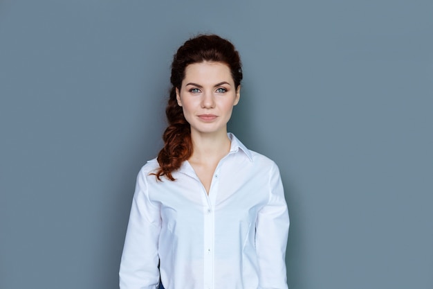 Successo sul lavoro. Gioiosa piacevole bella donna d'affari sorridendo e guardando a voi pur essendo di buon umore