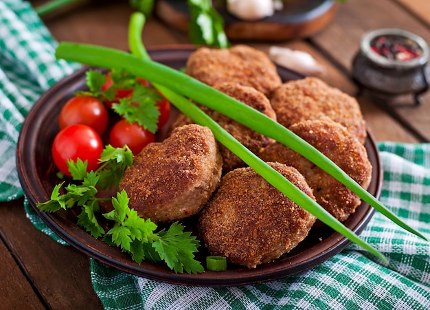 Succiose e deliziose cotolette di carne su un tavolo di legno in stile rustico