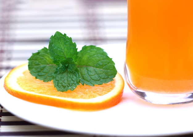 Succo d'arancia con fettine di arancia e foglie di menta