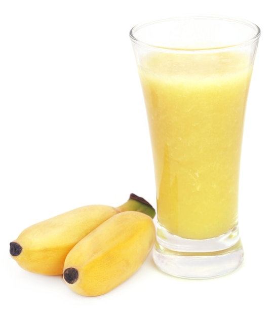 Succo di banana con banane fresche su sfondo bianco