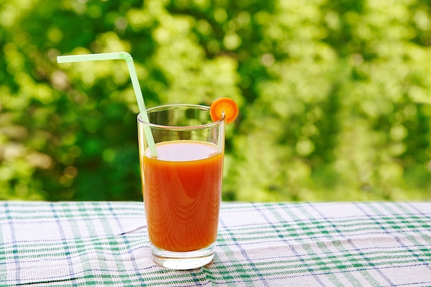 Succo di carota fresca in un bicchiere sul tavolo