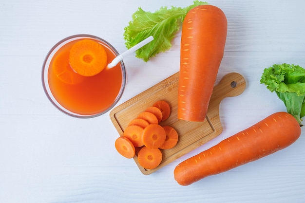 Succo di carota fresco sano sulla tavola bianca