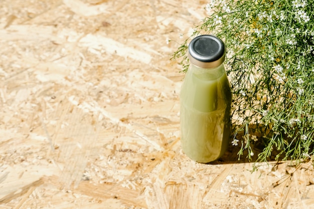 Succo di disintossicazione verde accanto al cespuglio