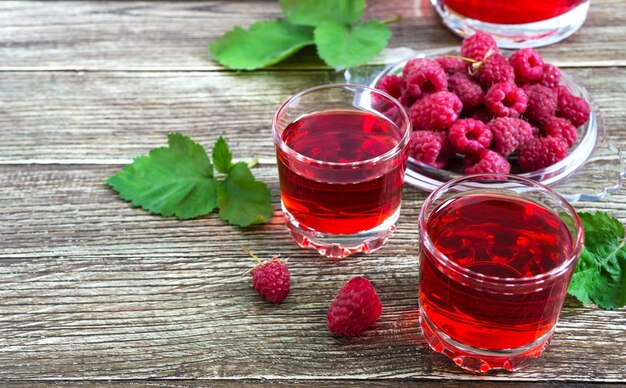 Succo di lampone in bicchieri e frutti di bosco freschi