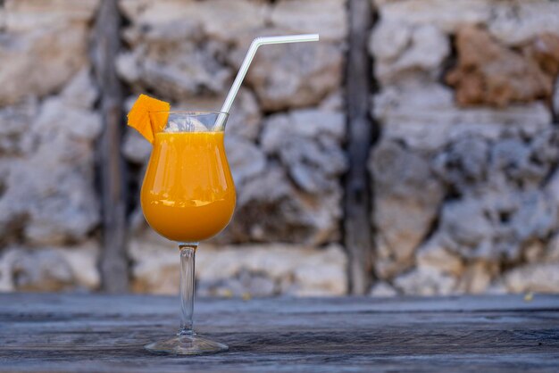 Succo di mango appena spremuto in un calice di vetro sullo sfondo di un vecchio muro di pietra Isola di Zanzibar Tanzania Africa orientale Close up