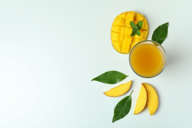 Succo di mango e frutta su superficie bianca