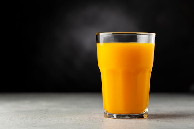 Succo di mango in tazza di vetro sul tavolo Frullato di mango