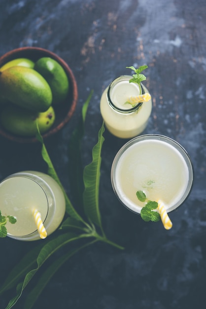 Succo di mango O Aam Panna o Panha in un bicchiere trasparente con frutta verde intera, messa a fuoco selettiva