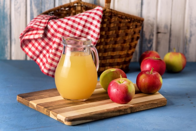 Succo di mela biologico sano in una brocca Tovagliolo rosso Mele rosse orizzontale Rustico