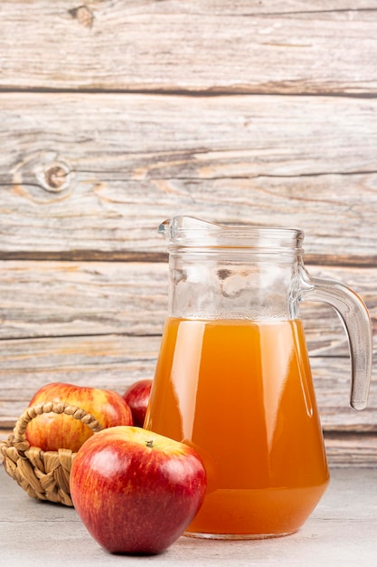 Succo di mela e mele rosse sul tavolo.