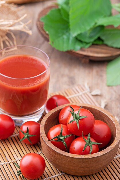 Succo di pomodoro. Bicchiere di succo di pomodoro con verdure su fondo in legno