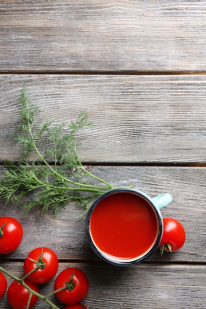 Succo di pomodoro fatto in casa a colori tazze di spezie e pomodori freschi su fondo di legno