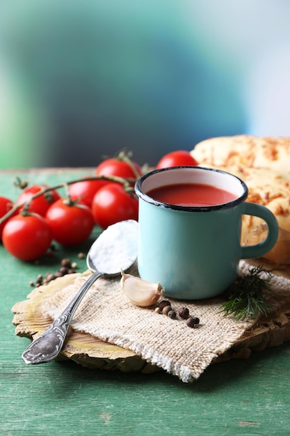 Succo di pomodoro fatto in casa in tazza di colore grissini spezie e pomodori freschi su tavola di legno su luminoso