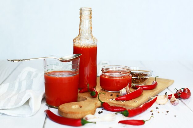 Succo di pomodoro fresco e pomodori su un tagliere di legno