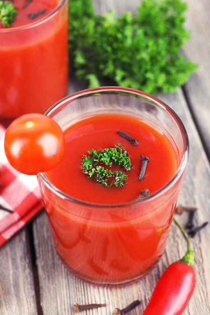 Succo di pomodoro in vetro e verdure fresche sul tovagliolo su fondo di legno