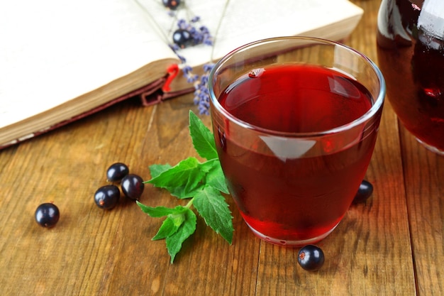 Succo di ribes fresco con frutti di bosco e libro sul tavolo da vicino