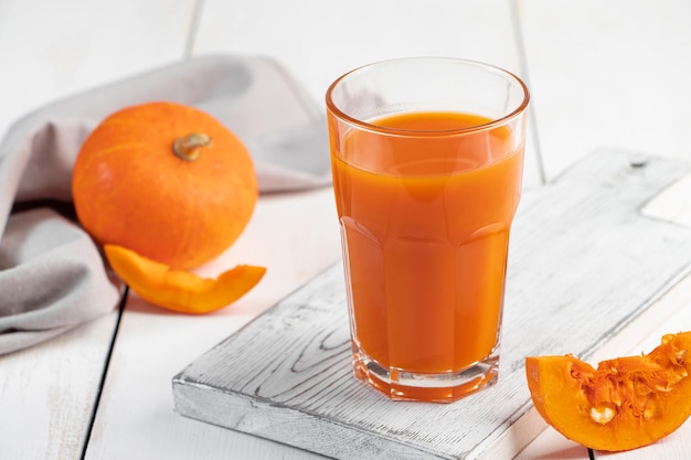 Succo di zucca in vetro su sfondo bianco Bevanda vegetale detox Cibo vegano sano Concetto di dieta