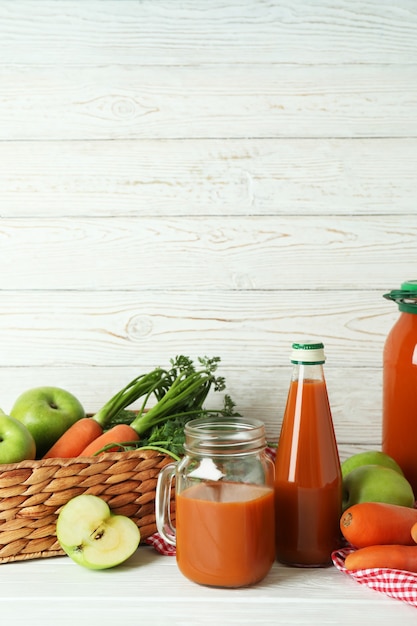 Succo ed ingredienti della carota della mela su legno bianco