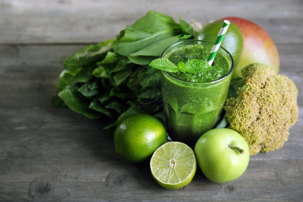 Succo verde sano con frutta e verdura sulla tavola di legno si chiuda