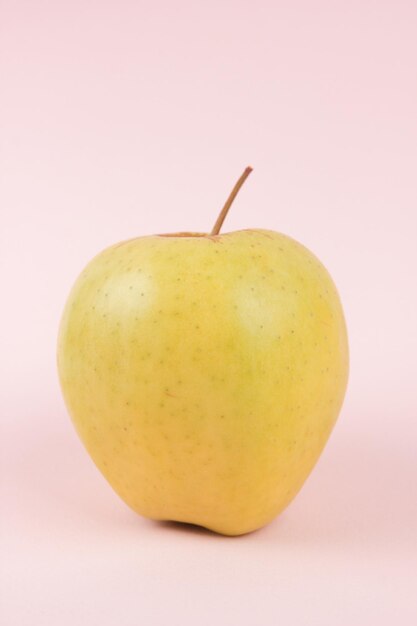 Succosa dolce mela intera su sfondo rosa Concetto di cibo sano Primo piano di un frutto dolce