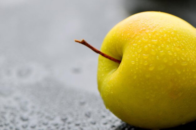 Succose mele gialle fresche con gocce d'acqua in un coltello da cucina per tagliare le mele