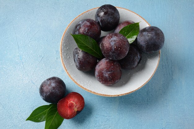 Succose prugne in un piatto. Prugne blu fresche.