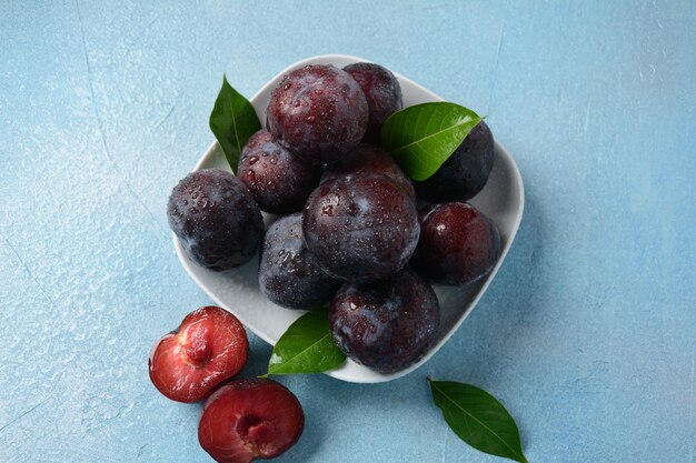 Succose prugne in un piatto. Prugne blu fresche.