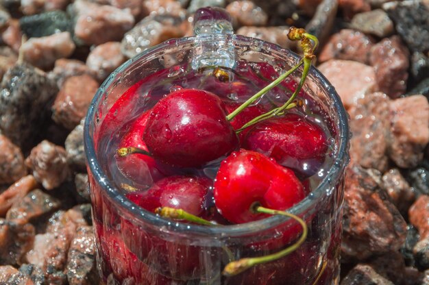 Sui noccioli della ciliegia in un bicchiere trasparente con acqua.