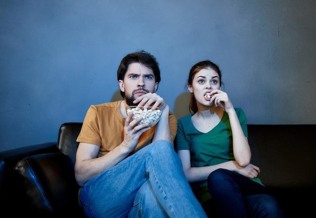 Sul divano e una bella donna sta guardando programmi televisivi