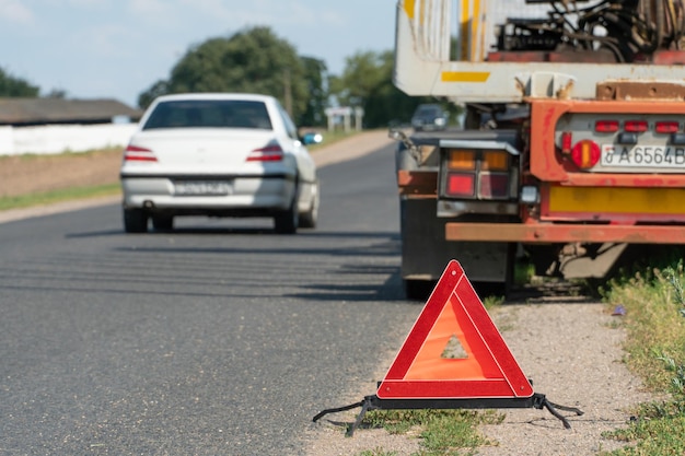 Sul lato della strada è presente un segnale di arresto di emergenza rosso Un incidente stradale che coinvolge un camion Trasporto di merci e relativi rischi sul lavoro