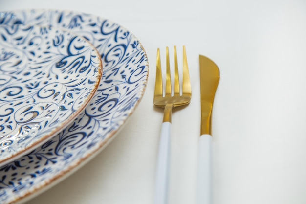 Sul lato due piatti da servire con motivi blu su uno sfondo bianco stanno uno su una parte del